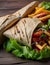 Traditional Shawarma Delight: Savory Chicken, Fries, and Fresh Veggies Wrapped in Pita - Rustic Brown Wall Setting. AI Generated