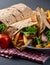 Traditional Shawarma Delight: Savory Chicken, Fries, and Fresh Veggies Wrapped in Pita - Rustic Brown Wall Setting. AI Generated