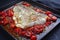 Traditional skinned backed skrei cod fish filet with tomato salsa ragu and herbs on a rustic metal sheet