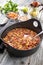 Traditional slow cooked Mexican chili con cane with mincemeat, beans and corn in a modern design roasting dish