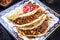 Traditional slow cooked Mexican chili con carne with tortillas on a colored plate