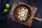 Traditional slow cooked Mexican pozole rojo in a modern design cast-iron roasting dish on an old rustic wooden board