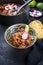 Traditional slow cooked Mexican pozole rojo with tortilla in a design bowl on a rustic board