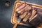 Traditional smoked barbecue wagyu beef brisket as piece and sliced on an old cutting board