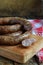 Traditional smoked sausage ring in a rustic style. Appetizing sausages made of pork and lamb with fresh herbs, spices on the