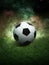 Traditional soccer ball on soccer field. Close up view of soccer ball football on green grass with dark toned foggy background.