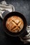 Traditional sourdough bread baked in a dutch oven on a black background