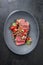 Traditional South American barbecue wagyu roast beef sliced with pico de gallo and salsa verde garnished in a modern design plate