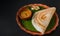 Traditional south indian food masala dosa, sambar and coconut chutney served on clay plate and banana leaf. studio shot