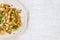 traditional soviet russian pasta dish, vermicelli, navy pasta, with meat on a white plate on a light fabric background. Minimalism