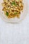 traditional soviet russian pasta dish, vermicelli, navy pasta, with meat on a white plate on a light fabric background. Minimalism