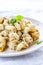 traditional soviet russian pasta dish, vermicelli, navy pasta, with meat on a white plate on a light fabric background. Minimalism