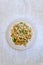 traditional soviet russian pasta dish, vermicelli, navy pasta, with meat on a white plate on a light fabric background. Minimalism