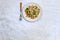 traditional soviet russian pasta dish, vermicelli, navy pasta, with meat on a white plate on a light fabric background. Minimalism