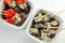 The traditional Spanish appetizers of olives, tomatoes and anchovies in a white ceramic bowls