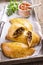 Traditional Spanish baked empanada de carne with minced meat and vegetable on a design tray