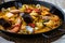 Traditional spanish seafood paella dish in a black pan. Mussels, Amandi and prawns on a pillow of rice. Close-up.