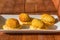 Traditional spanish snack- croquettes fried in oil, with yellow cream sauce on white plate at sunny kitchen.