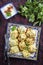 Traditional steamed Russian pelmeni with cayenne pepper on a rustic design plate