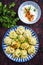 Traditional steamed Russian pelmeni with cayenne pepper on a rustic design plate