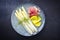 Traditional steamed white asparagus with cured ham and boiled potatoes garnished with butter sauce on a Nordic design plate