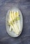 Traditional steamed white asparagus garnished with butter sauce and herbs on a design plate