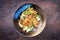 Traditional stir-fried Thai phat phak kung with mie noodles in a design bowl
