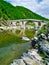 Traditional stone arched bridge over river in Xanthi, Thrace, Greece. Vivid nature landscape, bridge reflecting on river water