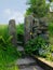 Traditional stone gate or stile in a dry stone wall with flowers and ferns in front of a spring green meadow