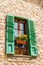 Traditional stone wall window with ceramic flower pot decorations in Valdemossa village, Mallorca, Spain