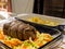 A traditional Sunday Roast meal of a topside roast beef joint and potatoes with herbs and olive oil