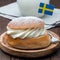 Traditional swedish dessert Semla, also called Shrove bun, with almond paste and whipped cream filling, served with milk,  square
