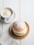Traditional Swedish Semla bun served in a cafe with a cup of coffee latte. Delicious pastry with whipped cream. Generative AI