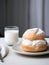 Traditional Swedish Semla bun served in a cafe with a glass of milk. Delicious pastry with whipped cream. Generative AI