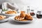 Traditional sweet and savory American dish of crunchy fried chicken and waffles drizzled with maple syrup. Hearty comfort food