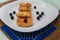 Traditional syrniki or cottage cheese pancakes with blueberries on white plate with blue napkin on kitchen table