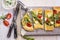Traditional tarte flambee with green asparagus, tomatoes and mozzarella on a stone design tray
