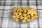 Traditional tasty Czech gingerbreads, Christmas snowflakes and reindeer on glass plate on grey chequered tablecloth