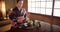 Traditional, teapot and Japanese woman with tea for culture with herbs, leaves and flavor in home. Kimono, ceremony and