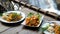 Traditional thai food in outdoor cafe with nature waterfall background. Fried noodle with prawn pad thai and chicken