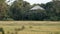 Traditional Thai house next to a field