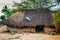 Traditional thatch hut with satellite TV dish