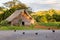 Traditional thatched roofed wooden barn surrounded by dark hens in the Vinales Valley at sundown