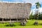 Traditional thatched yapese men`s meeting house called faluw fale and a bank of stone money rai. Yap island, Micronesia, Oceania