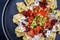 Traditional Turk manti steamed with mincemeat and paprika tomato salad on a modern design plate