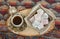 Traditional Turkish delight in traditional bowl with Turkish coffee. Fabric background.