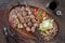 Traditional Turkish lamb kebab barbecue skewer with cabbage and tomato onion salad on a rustic plate