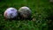 Traditional two white used cricket balls on a ground