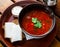 Traditional Ukrainian borsch with sour cream in bowl, bread with bacon