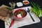 Traditional Ukrainian Russian borscht with beans on the bowl. Plate of red beet root soup borsch on black table.